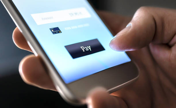 Una persona pagando algo con la tarjeta de crédito dentro de su teléfono móvil